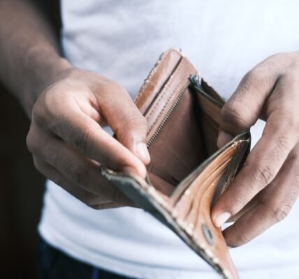 person holding brown leather bifold wallet