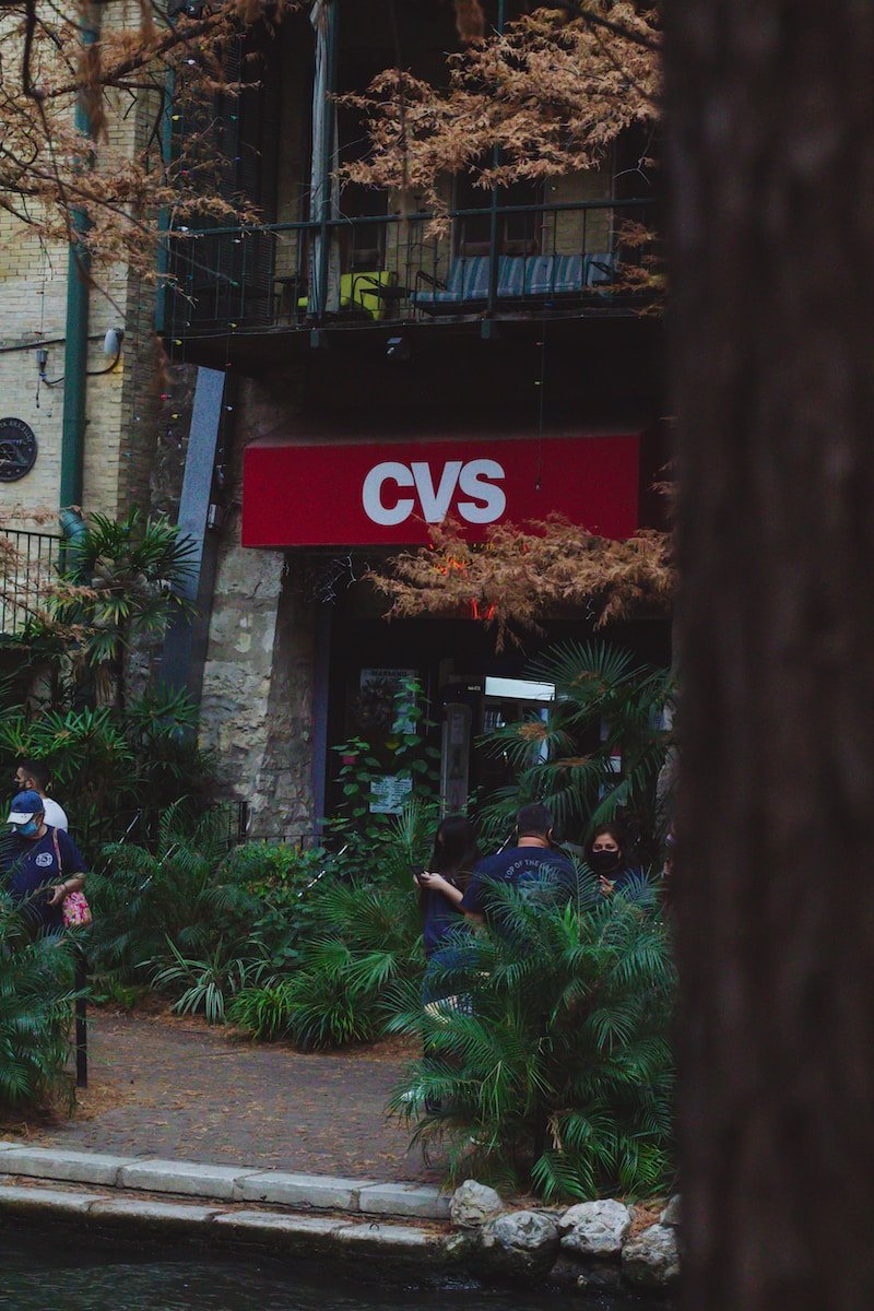 people sitting on green grass near red and white store during daytime