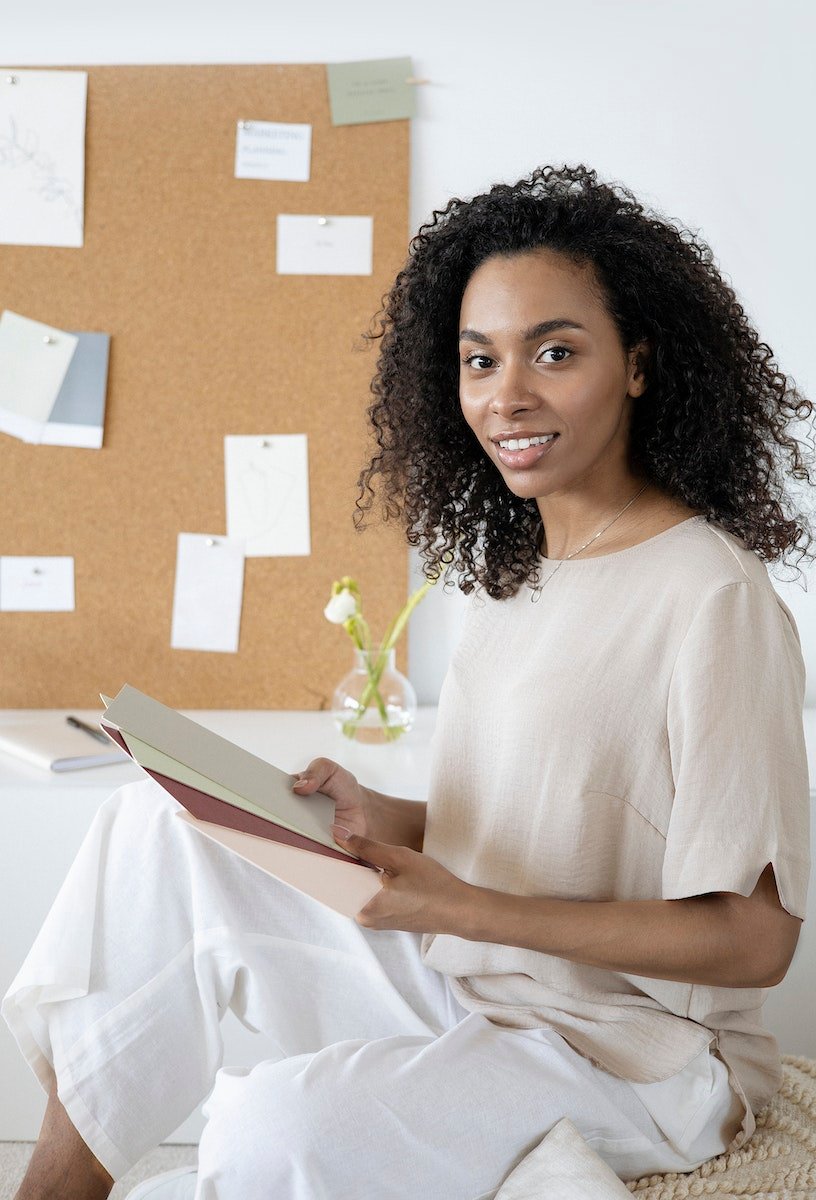 Curly Haired Woman Holding Sheets of Hard Papers