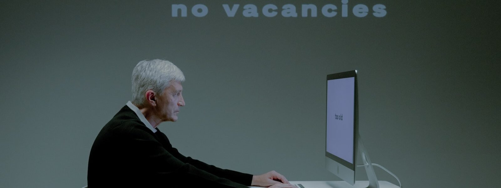 An Elderly Man with a Serious Face while using a Computer