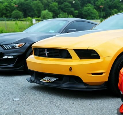 parked yellow Ford Mustang coupe and black