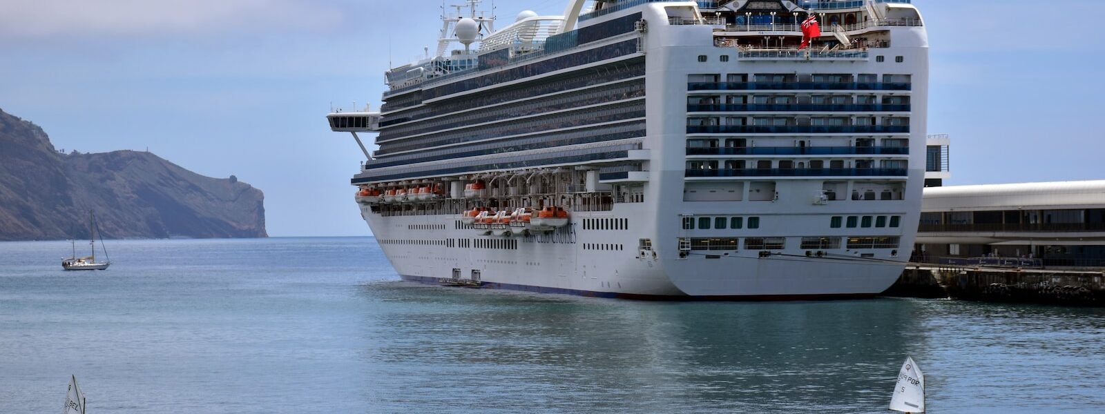 a large cruise ship in the water next to a dock