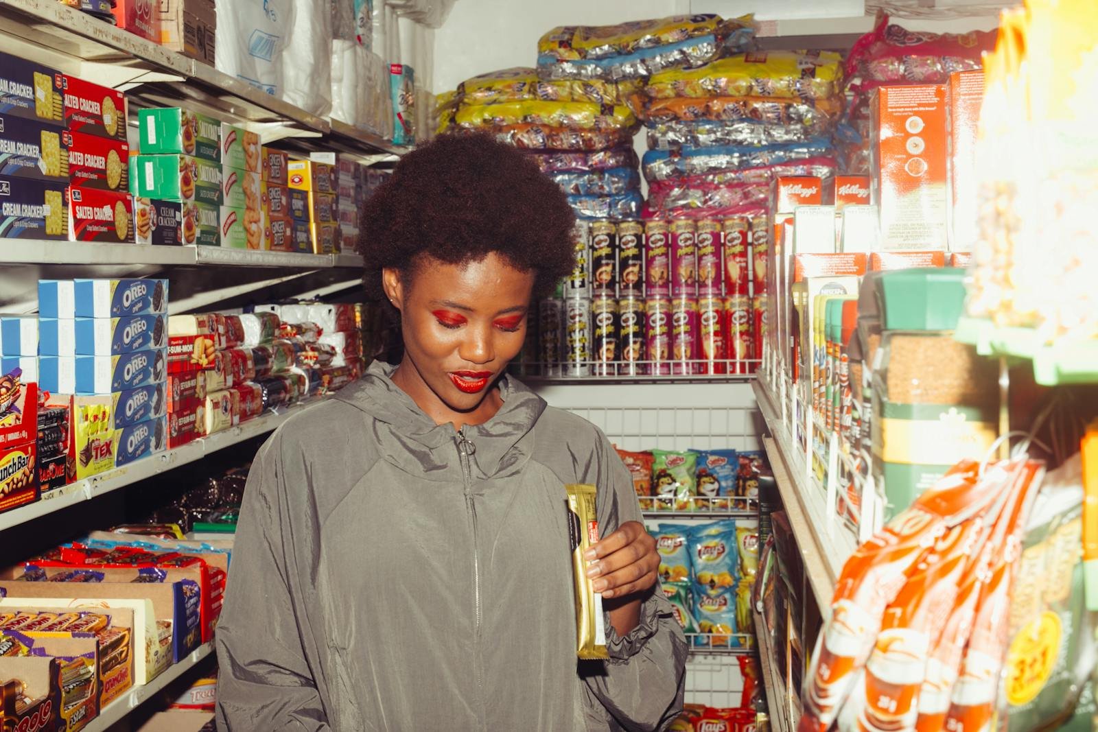 Positive ethnic woman choosing food in grocery store