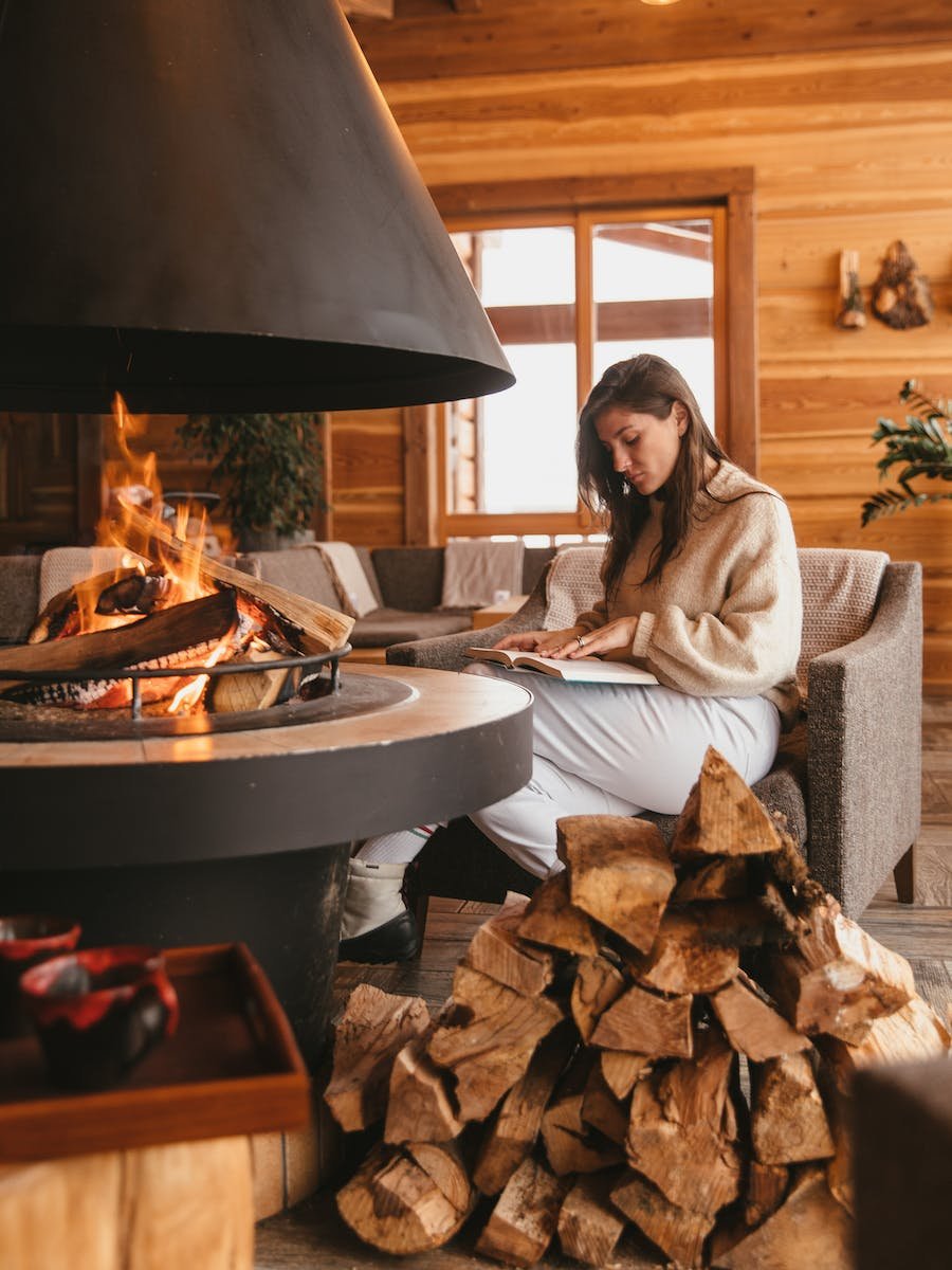 Woman Reading Near the Fireplace